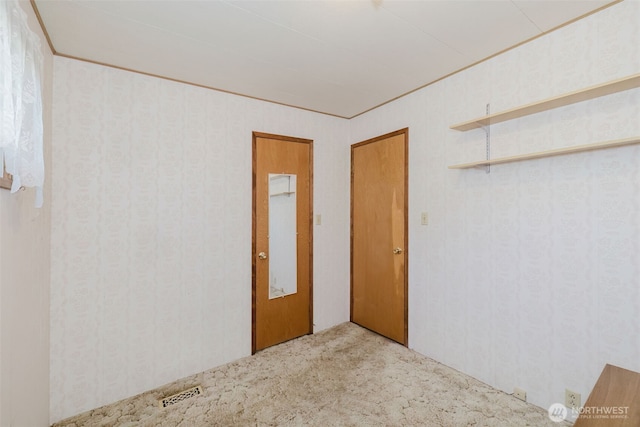 spare room featuring carpet flooring and visible vents