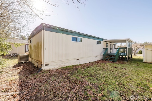 rear view of property with crawl space, a yard, a wooden deck, and central AC unit