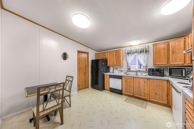 kitchen with light floors, light countertops, vaulted ceiling, a sink, and black appliances