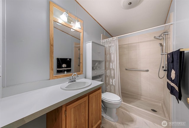 bathroom featuring toilet, tiled shower, and vanity