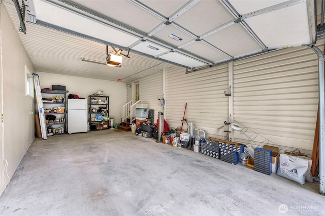 garage with a garage door opener and freestanding refrigerator