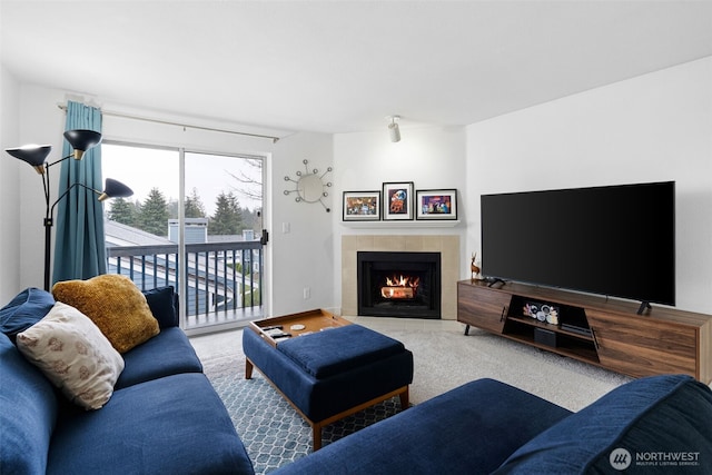 living area featuring a fireplace, carpet flooring, and baseboards