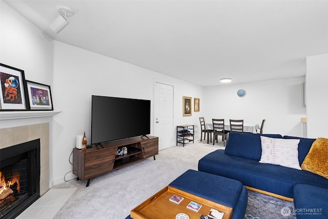 carpeted living room with a tile fireplace