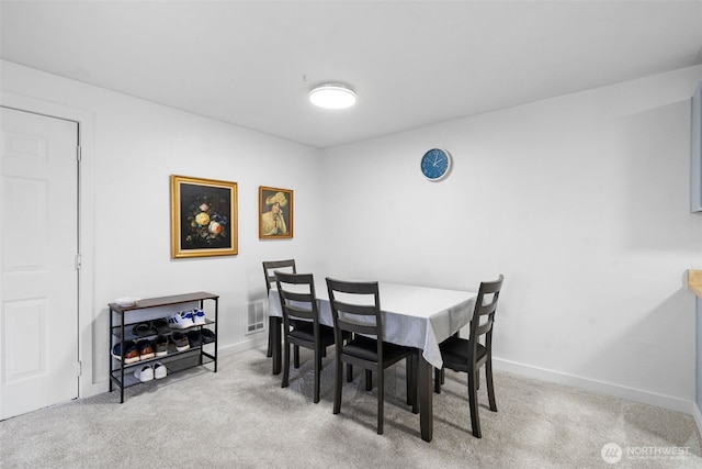 carpeted dining area featuring visible vents and baseboards