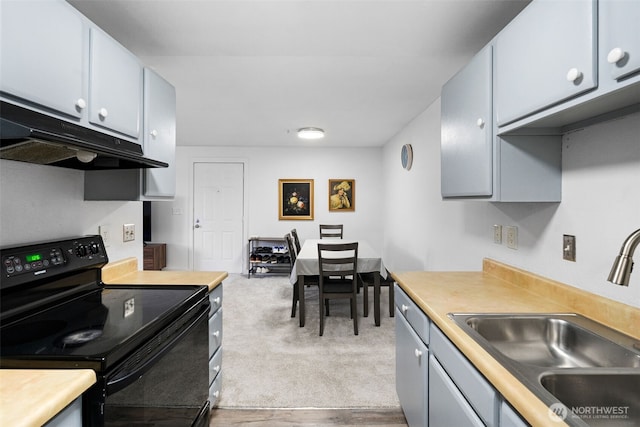 kitchen featuring light colored carpet, light countertops, black electric range, under cabinet range hood, and a sink