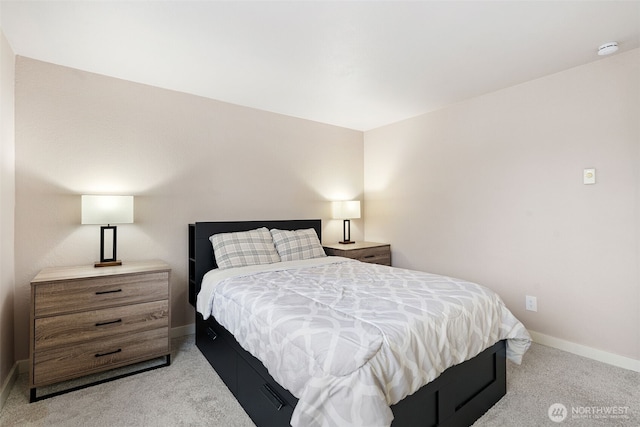 bedroom featuring light carpet and baseboards