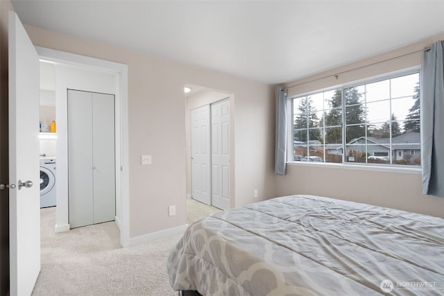 carpeted bedroom with a closet, washer / clothes dryer, and baseboards