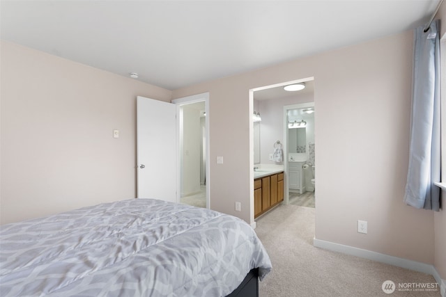 bedroom featuring light carpet, ensuite bath, and baseboards