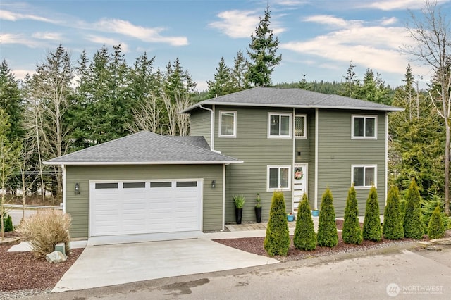 view of front of house with driveway, a shingled roof, and a garage