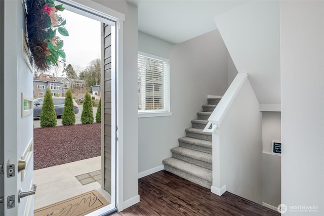 staircase featuring wood finished floors and baseboards