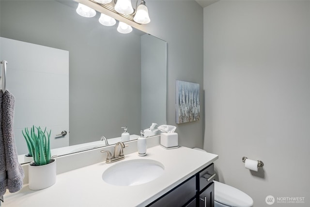 bathroom with a notable chandelier, toilet, and vanity