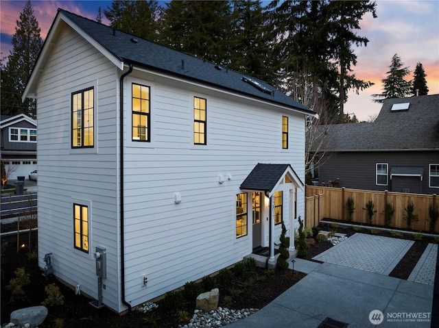 exterior space with a shingled roof and fence