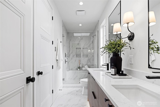 bathroom with toilet, a sink, marble finish floor, a marble finish shower, and double vanity