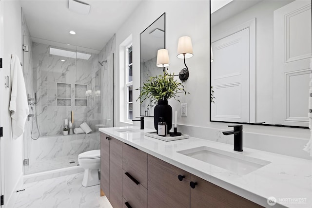 bathroom featuring marble finish floor, a marble finish shower, a sink, and toilet