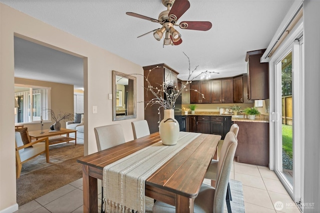 dining room featuring ceiling fan, a textured ceiling, and light tile patterned flooring