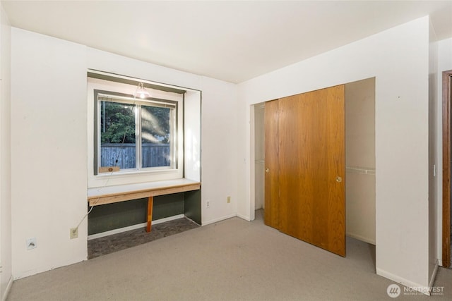 unfurnished bedroom with carpet flooring, baseboards, and a closet