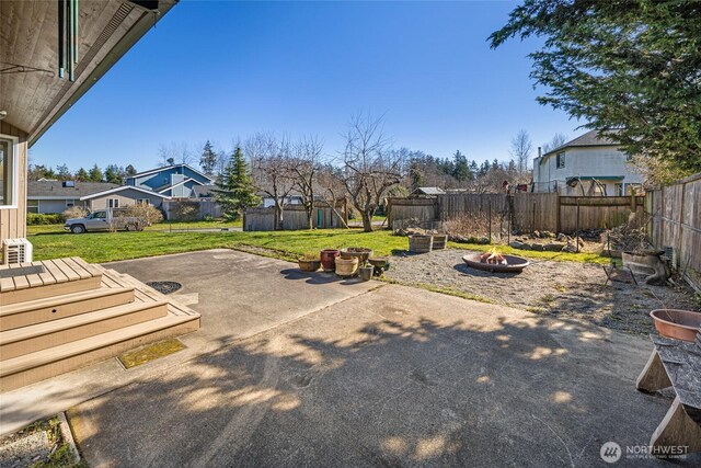 view of yard with a patio area, a fenced backyard, and an outdoor fire pit