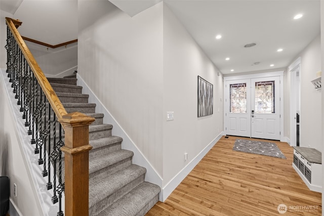 foyer entrance with french doors, recessed lighting, stairway, light wood-style floors, and baseboards