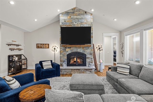 living area with lofted ceiling, light wood-type flooring, and a fireplace