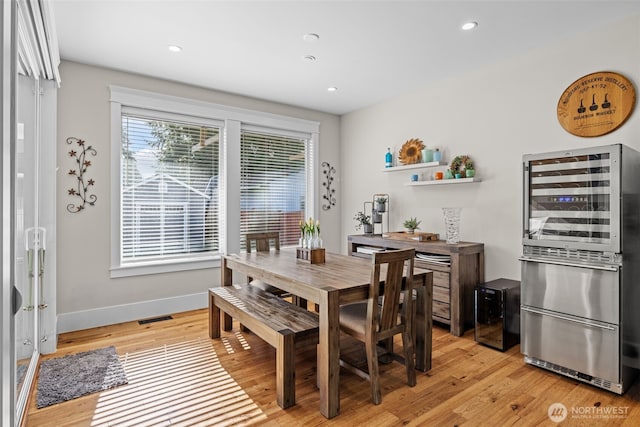 dining space with light wood-style floors, wine cooler, visible vents, and recessed lighting