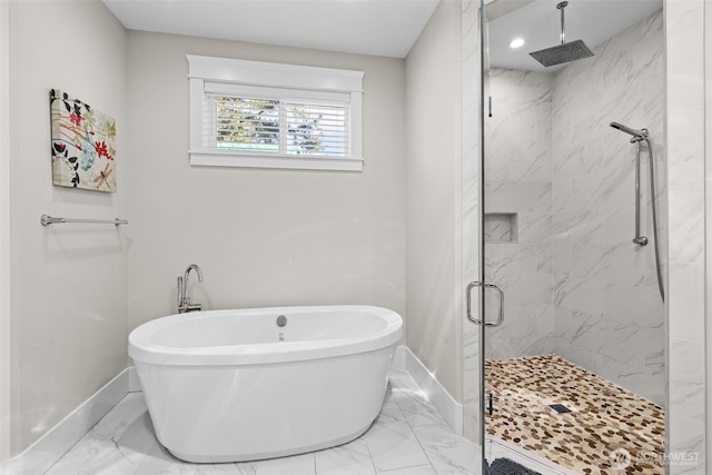 bathroom with marble finish floor, a soaking tub, a shower stall, and baseboards