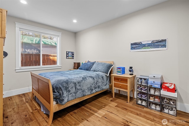 bedroom with baseboards, recessed lighting, and light wood-style floors