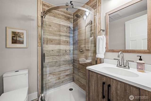 bathroom with a shower stall, toilet, and vanity