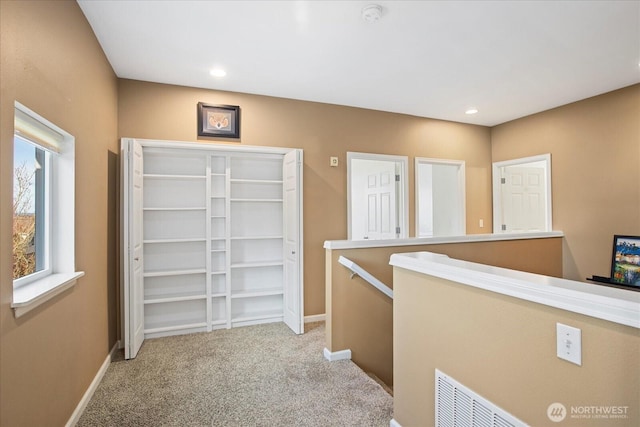 hall featuring visible vents, baseboards, an upstairs landing, carpet floors, and recessed lighting