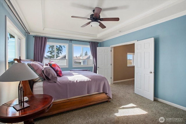 carpeted bedroom with baseboards, a raised ceiling, and ornamental molding