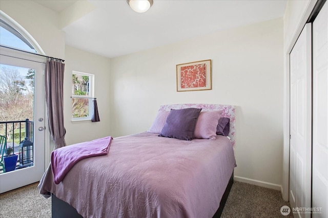 carpeted bedroom featuring baseboards and access to exterior