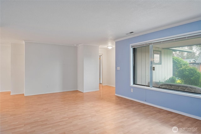 unfurnished room with a textured ceiling, visible vents, baseboards, light wood-style floors, and crown molding