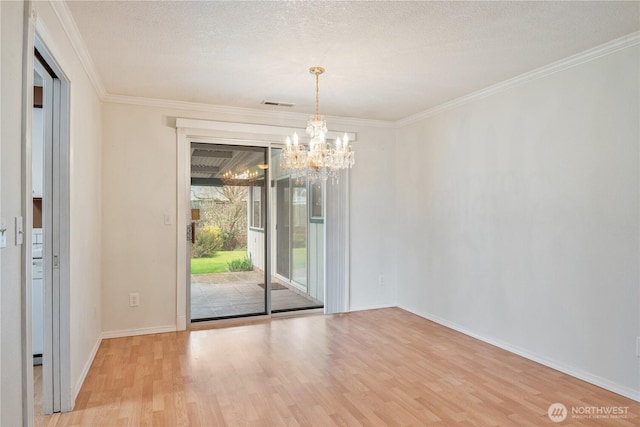 empty room with visible vents, ornamental molding, wood finished floors, a textured ceiling, and a notable chandelier