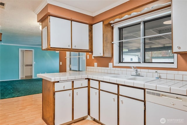 kitchen with white dishwasher, crown molding, light wood-style floors, white cabinetry, and a sink