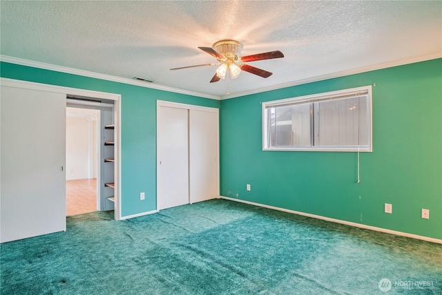 unfurnished bedroom with visible vents, a ceiling fan, ornamental molding, a textured ceiling, and carpet flooring