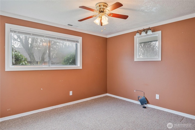 unfurnished room with visible vents, baseboards, ornamental molding, carpet, and a textured ceiling