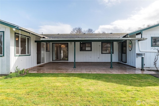 back of property with metal roof, a yard, and a patio