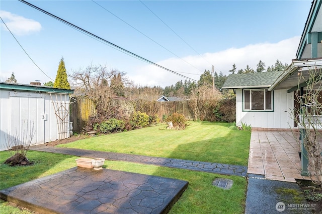 view of yard with a patio area, a fenced backyard, and an outdoor structure