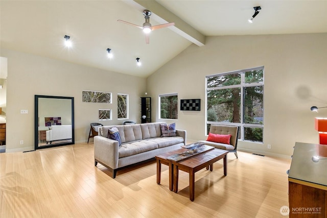 living area featuring beamed ceiling, high vaulted ceiling, a ceiling fan, and light wood finished floors