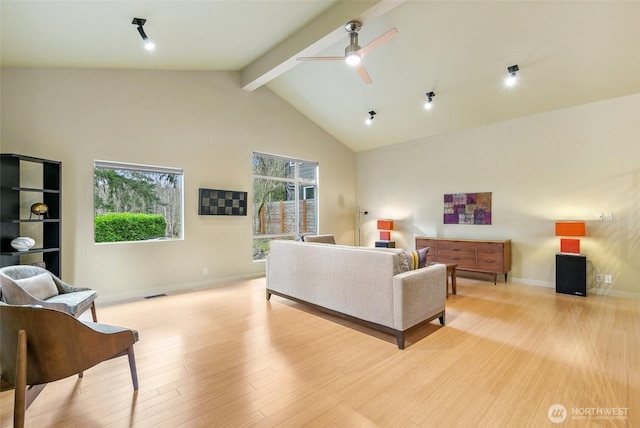 living room with light wood finished floors, visible vents, baseboards, beamed ceiling, and high vaulted ceiling