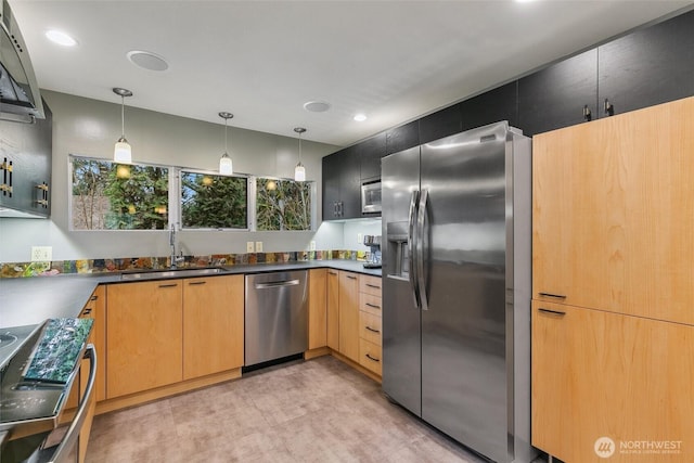 kitchen with dark countertops, recessed lighting, appliances with stainless steel finishes, hanging light fixtures, and a sink