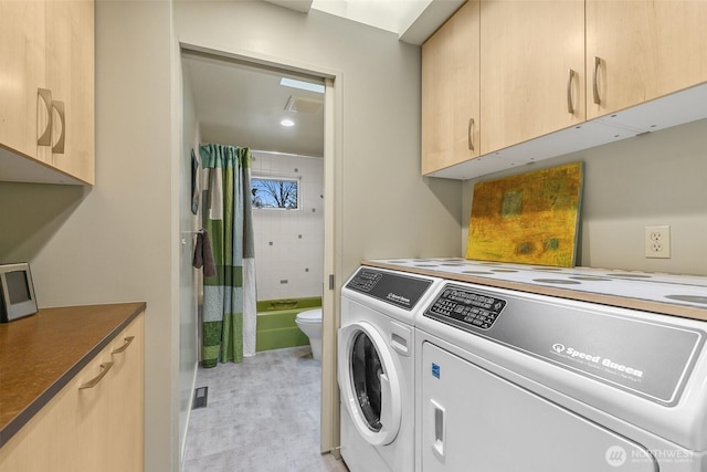 laundry room featuring visible vents, cabinet space, and separate washer and dryer