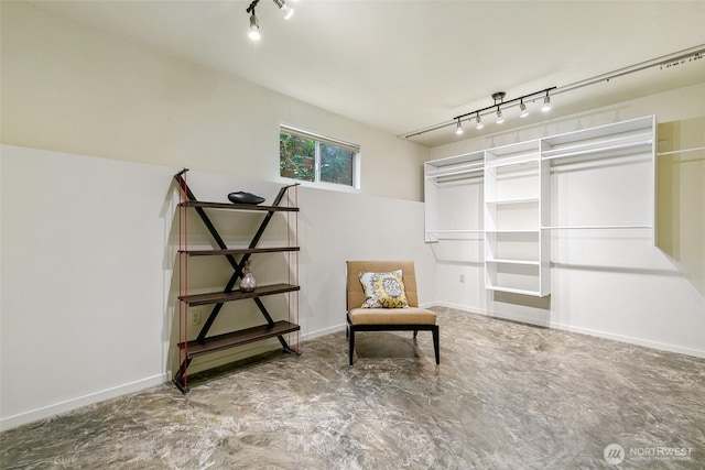 unfurnished room featuring rail lighting and baseboards