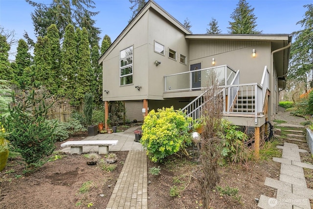 rear view of house featuring a patio, stairs, and fence