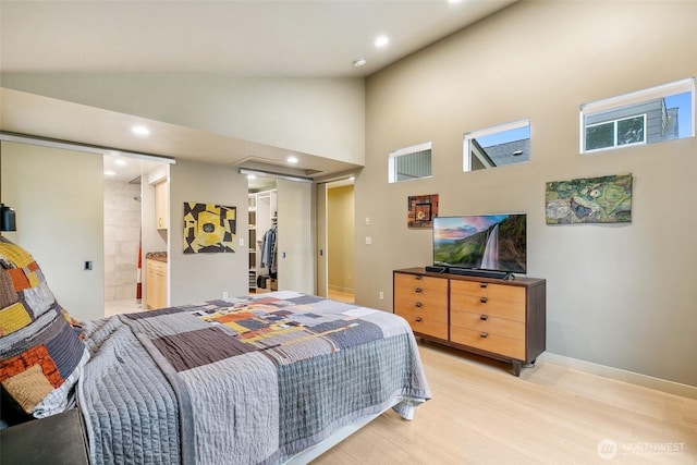 bedroom with recessed lighting, a walk in closet, high vaulted ceiling, and light wood-style flooring