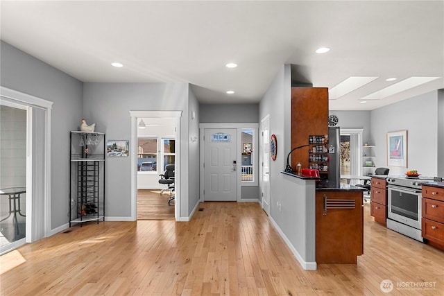 kitchen with brown cabinets, dark countertops, recessed lighting, light wood-style flooring, and high end stove