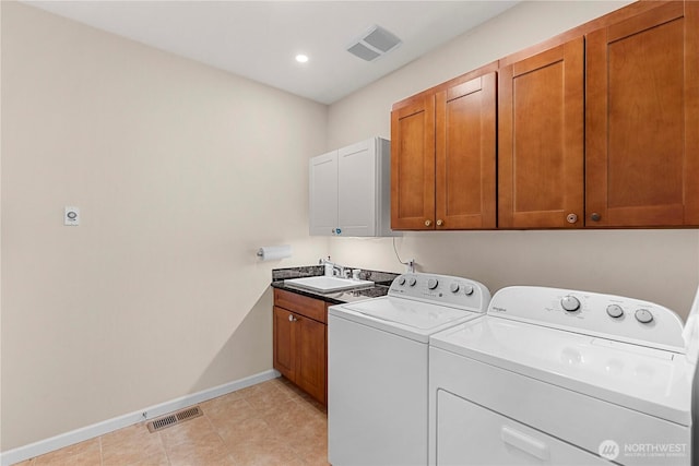 laundry area with cabinet space, visible vents, a sink, and washer and dryer