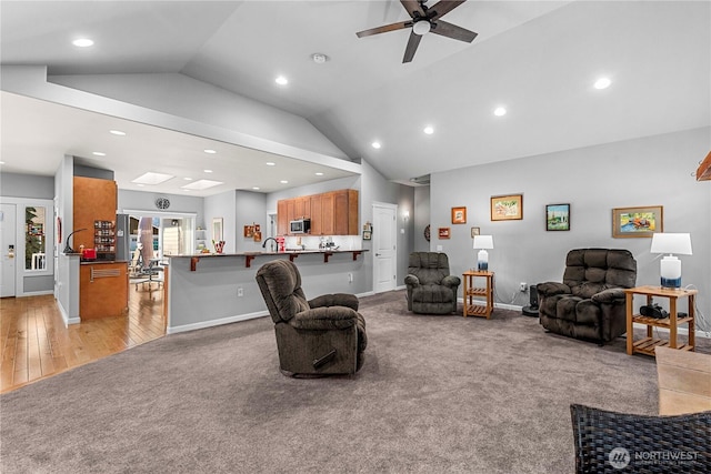 living area featuring vaulted ceiling, ceiling fan, recessed lighting, and light colored carpet