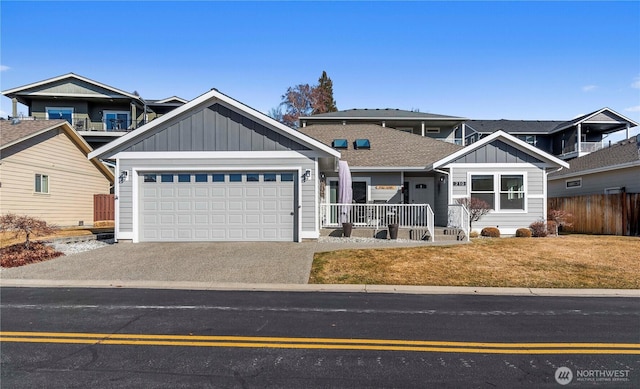 view of front of home with covered porch, concrete driveway, board and batten siding, a front yard, and a garage