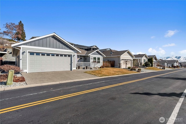 single story home featuring an attached garage, board and batten siding, fence, a residential view, and driveway