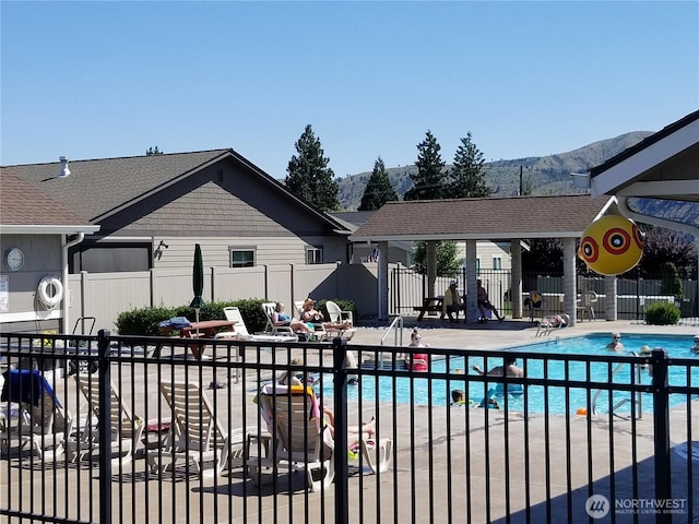 pool with fence, a mountain view, and a patio